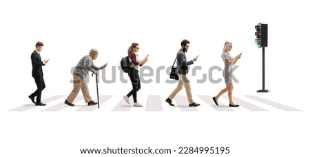 Full length profile shot of people crossing street at a pedestrian crossing and using mobile phones isolated on white background