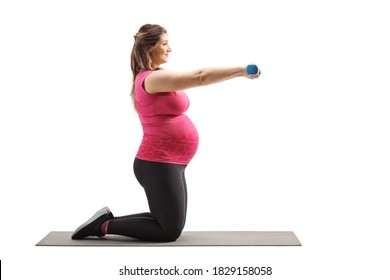 Full Length Profile Shot Of A Pregnant Woman Kneeling On A Mat And Exercising With Dumbbells Isolated On White Background