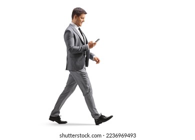 Full length profile shot of a professional man using a smartphone and walking isolated on white background - Powered by Shutterstock