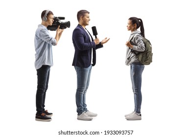 Full length profile shot of a reporter with a microphone and a cameraman interviewing a female student isolated on white background