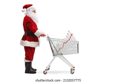 Full Length Profile Shot Of Santa Claus Standing With A Shopping Cart And A Bar Chart Inside Isolated On White Background