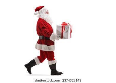 Full length profile shot of santa claus walking and carrying a present box isolated on white background - Powered by Shutterstock