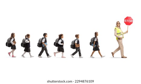 Full length profile shot of schoolchildren walking behind a teacher with stop traffic sign isolated on white background - Powered by Shutterstock