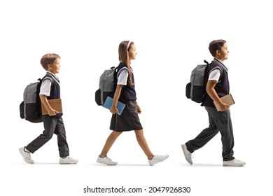 Full length profile shot of a schoolgirl and two schoolboys walking in line with books in their hands isolated on white background - Powered by Shutterstock