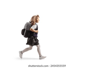 Foto de perfil larga de una colegiala con uniforme llevando una mochila y corriendo aislada sobre fondo blanco