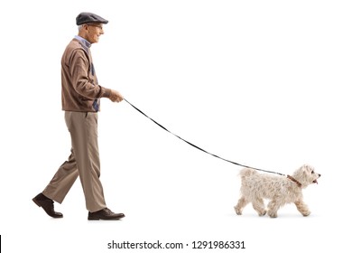 Full Length Profile Shot Of A Senior Walking A Dog Isolated On White Background
