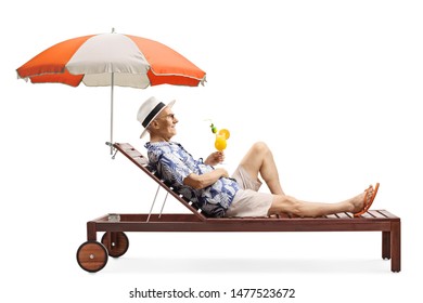 Full length profile shot of a senior man relaxing on a beach bed under umbrella with a cocktail isolated on white background - Powered by Shutterstock