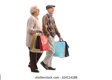 Full Length Profile Shot Of A Senior Couple With Shopping Bags Walking Isolated On White Background