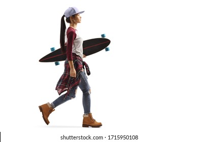 Full length profile shot of a teenage girl walking and carrying a longboard isolated on white background - Powered by Shutterstock