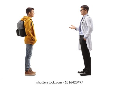 Full Length Profile Shot Of A Teenager Boy Listening To A Doctor Isolated On White Background