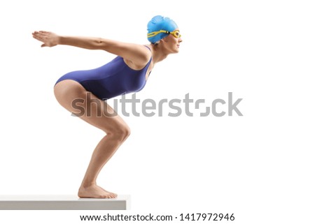Full length profile shot of a woman in a swimming suit and cap preparing to jump isolated on white background