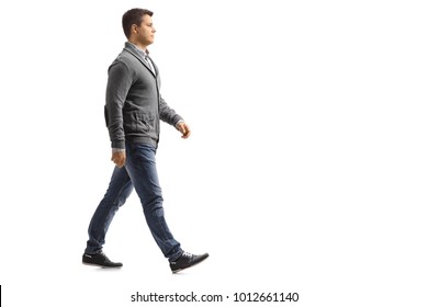 Full Length Profile Shot Of A Young Man Walking Isolated On White Background