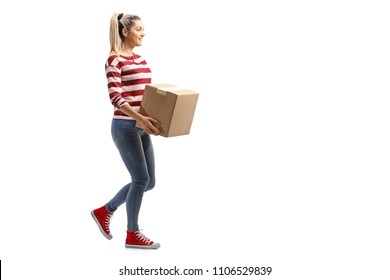 Full length profile shot of a young woman carrying a box and walking isolated on white background
