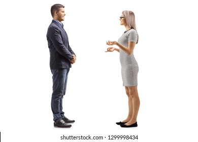 Full Length Profile Shot Of A Young Man And Woman Standing And Having A Conversation Isolated On White Background