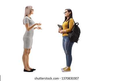 Full length profile shot of a young woman talking to a female student isolated on white background