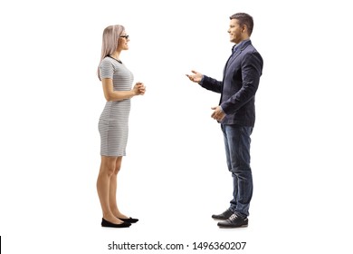 Full Length Profile Shot Of A Young Man And Woman Standing And Talking Isolated On White Background