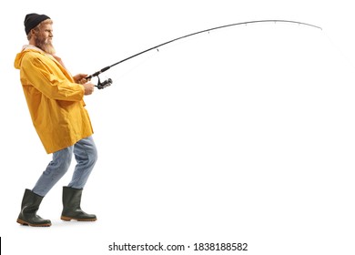 Full length profile shot of a young bearded fisherman catching with a fishing pole isolated on white background