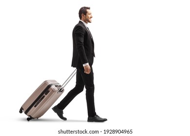 Full length profile shot of a young businessman in a suit walking and carrying a suitcase isolated on white background - Powered by Shutterstock