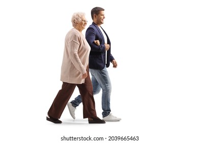 Full length profile shot of a young man walking with an elderly woman isolated on white background