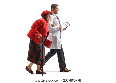 Full Length Profile Shot Of A Young Male Doctor Walking And Holding An Elderly Woman Under Shoulder Isolated On White Background