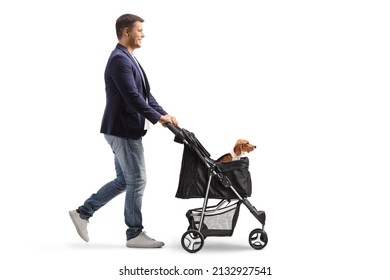 Full Length Profile Shot Of A Young Man Walking And Pushing A Dog Stroller With A Beagle Isolated On White Background