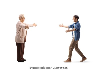 Full length profile shot of a young man walking towards an elderly woman with arms wide open isolated on white background