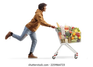 Full length profile shot of a young african american man running with a shopping cart isolated on white background