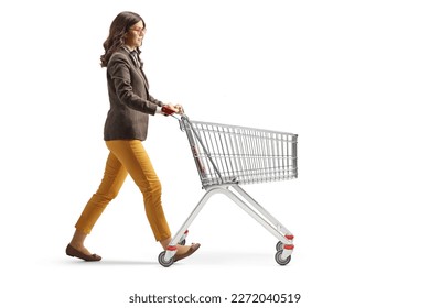 Full length profile shot of a young professional woman alking with an empty shopping cart isolated on white background