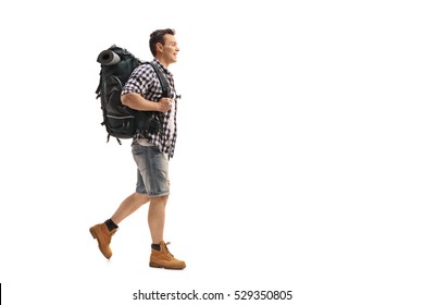 Full length profile shot of a young hiker walking isolated on white background - Powered by Shutterstock