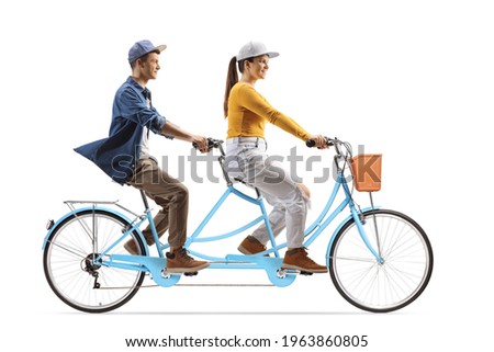 Full length profile shot of a young male and female riding a tandem bicycle isolated on white background