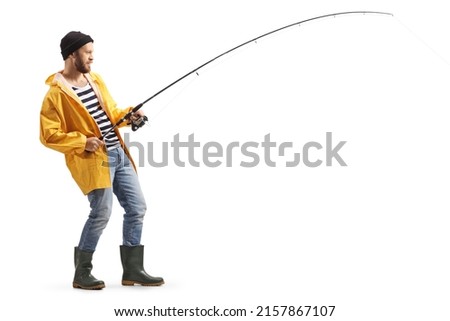 Full length profile shot of a young man in a raincoat and boots fishing with a rod isolated on white background