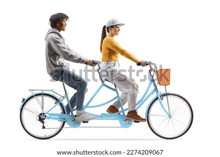 Full length profile shot of a young african american male and a caucasian female riding a tandem bicycle isolated on white background