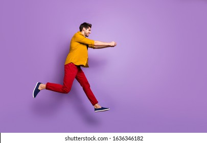 Full length profile side photo of cheerful funky guy jump run hold hand copyspace try pull rope in game wear casual style clothing isolated over violet color background - Shutterstock ID 1636346182