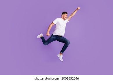 Full Length Profile Side Photo Of Young Man Happy Positive Smile Jump Fly Air Superman Isolated Over Violet Color Background