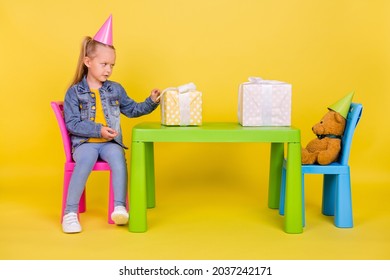 Full Length Profile Side Photo Of Young Small Girl Unhappy Dislike Gift Box Celebration Isolated Over Yellow Color Background