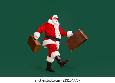 Full length profile side photo of white grey hair bearded santa claus hold suitcase go copyspace x-mas christmas resort wear headwear sunglass isolated bright shine color background - Powered by Shutterstock