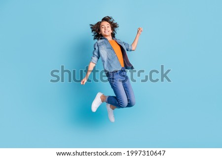 Full length profile side photo of young boy happy positive smile jump wear denim isolated over blue color background