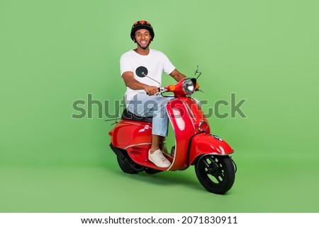 Full length profile side photo of young afro man drive vintage motor bike isolated over green color background