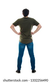 Full Length Rear View Of Casual Young Man Standing With Hands On Hips Looking Ahead Isolated Over White Background. Backside Male Body Confident Gesture. 