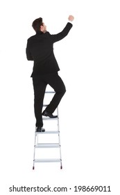 Full Length Rear View Of Young Businessman Climbing Career Ladder Over White Background