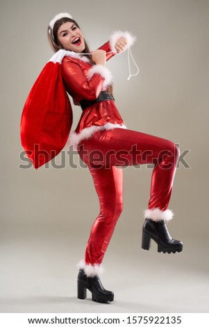 Full length of a Santa girl with a sack full of presents