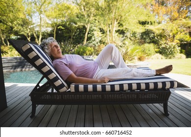 Full Length Of Senior Woman Resting On Lounge Chair At Porch