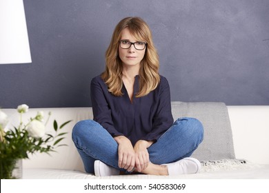 Full Length Shot Of An Attractive Middle Aged Woman Relaxing On Sofa At Home.