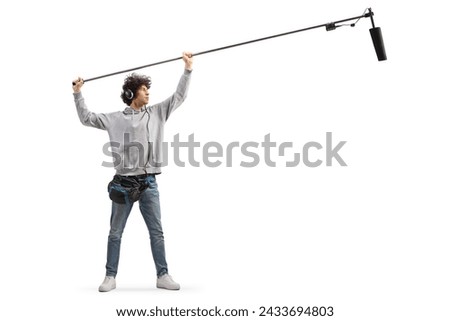 Full length shot of audio operator holding a microphone on set  isolated on white background