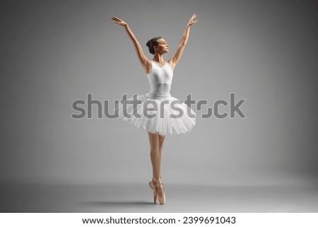 Full length shot of a ballerina dancing isolated on grey background