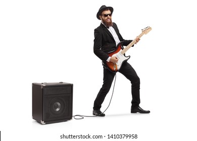 Full Length Shot Of A Bearded Man Playing An Electric Guitar Plugged In An Amp Isolated On White Background
