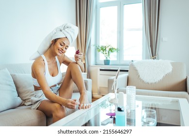 Full length shot of a beautiful young woman doing pedicure at home during quarantine. She is sitting on her cozy bed in the bedroom and painting her toenails.

 - Powered by Shutterstock