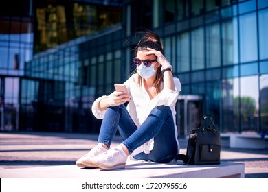 Full length shot of careworn businesswoman wearing face mask for prevention and text messaging while on the street. Don't touch your face - Powered by Shutterstock