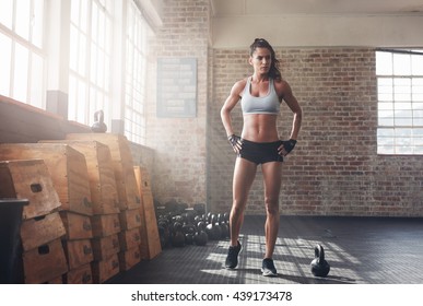 Full Length Shot Of Determined Fitness Woman Walking In The Crossfit Gym. Muscular Sportswoman Warming Up Before A Intense Workout.