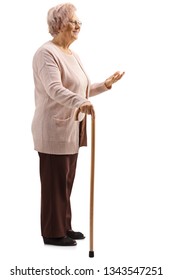 Full length shot of an elderly woman standing with a cane and gesturing with a hand isolated on white background